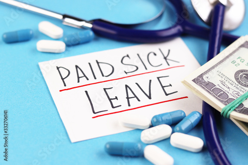 phonendoscope with dollars on a blue background. white tablets and a piece of paper with the text of the paid sick leave. money in a bundle and blue capsules