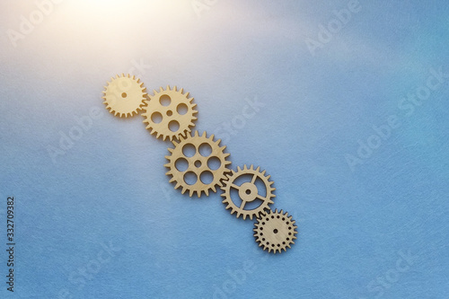 wooden gears on a blue background. Mechanism, interaction.