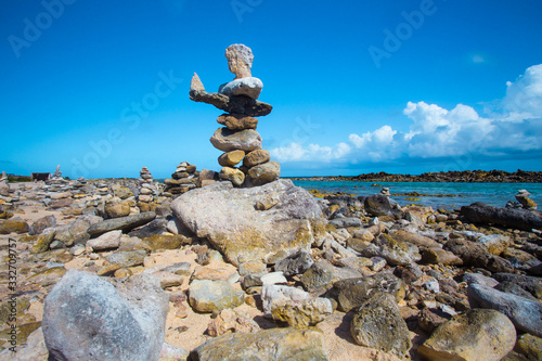 Stacked rocks balance on rocky beach in Aruba