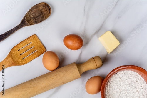 Kitchen tools, eggs, flour and butter.