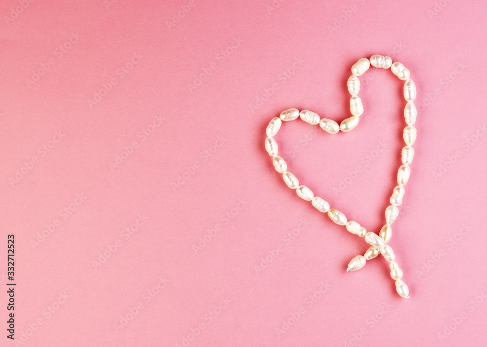 heart-shaped pearl jewelry. background for Valentine's Day. women's handmade jewelry. white heart on pink background