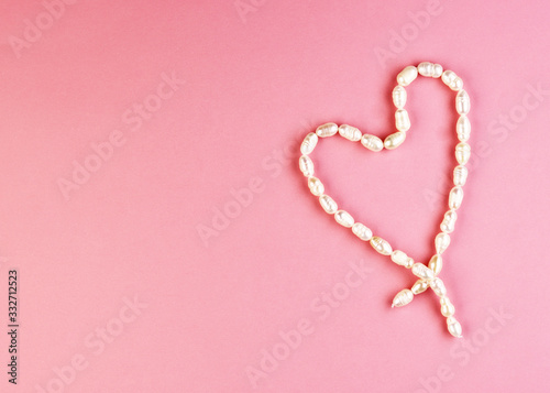 heart-shaped pearl jewelry. background for Valentine's Day. women's handmade jewelry. white heart on pink background