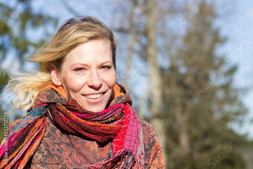 Portrait of a happy 40-year-old woman. Windy, early spring day