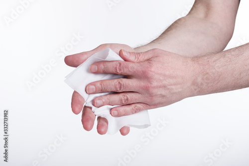 Human hands use a wet wipe close-up on a white background. Concept of infection.