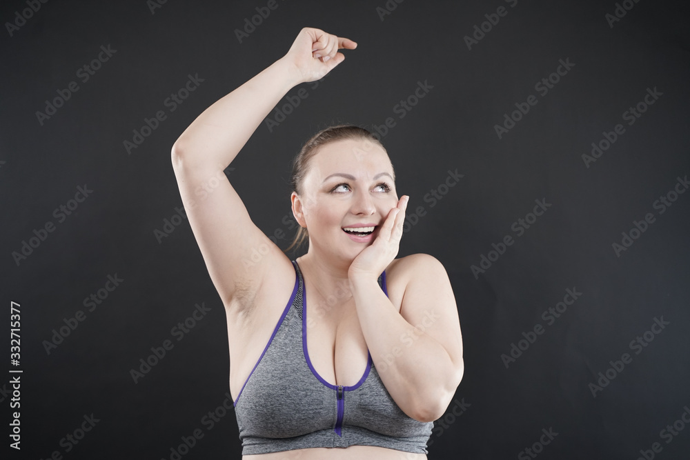 Fototapeta premium young happy plus size caucasian woman shows her unshaved armpit