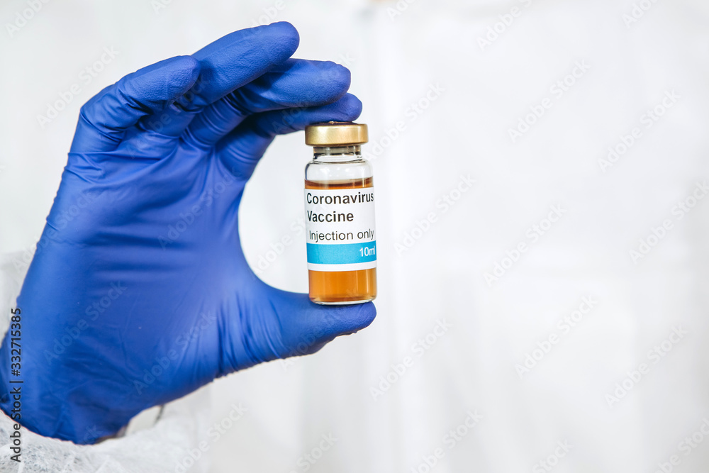the doctor is holding a test tube with a coronavirus vaccine on a white background. Vaccine covid-19. Pandemic 2020. The doctor's hands are in blue medical gloves. A cure for the virus. the doctor is holding a test tube with a coronavirus vaccine on a white background. Vaccine covid-19. Pandemic 2020. The doctor's hands are in blue medical gloves. A cure for the virus.