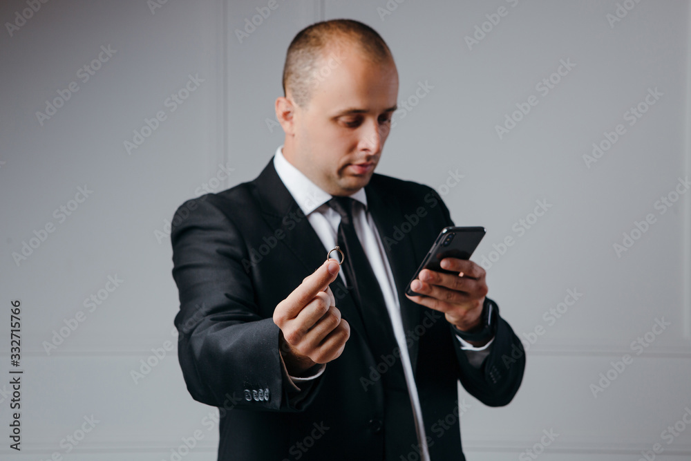 Businessman proposes with ring in hand while look on the phone Businessman proposes with ring in hand while look on the phone