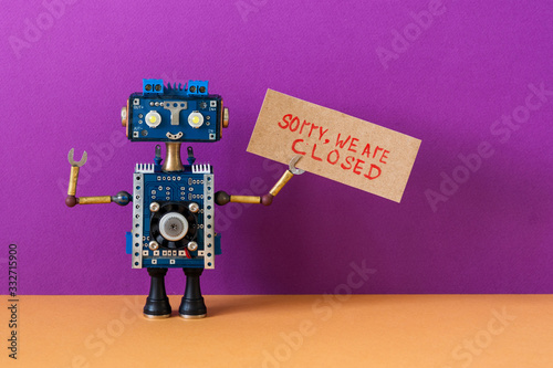 Crisis bankruptcy concept. Closed for maintenance, vacation or service works. Robot handyman holds poster with handwritten message Sorry, we are closed. Purple background