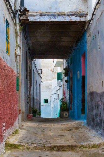 View of the old streets of Tetouan Medina quarter in Northern Morocco. A medina is typically walled, with many narrow and maze-like streets and often contain historical houses, palaces, places. © Renar