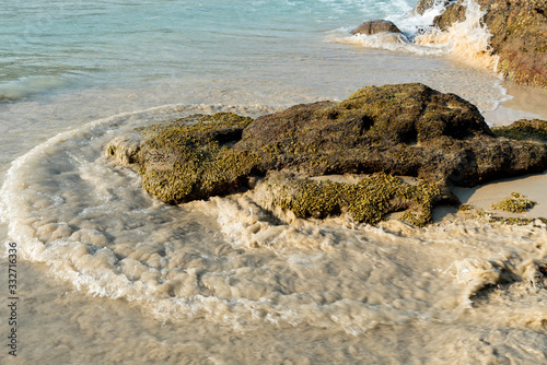 wave on the beach around stone