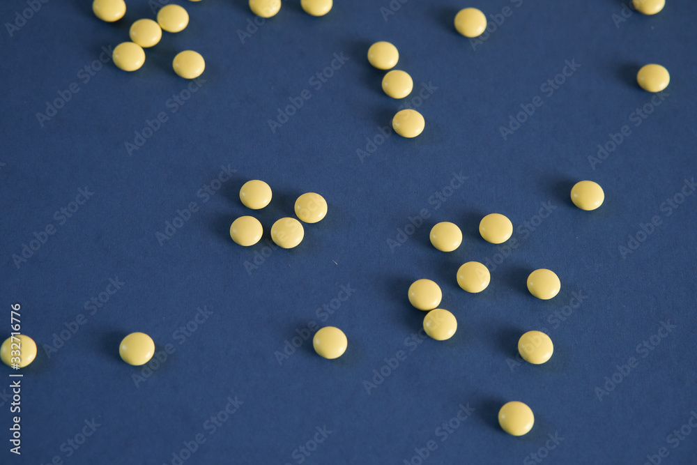 Yellow round tablets on a blue background. Free space for text Yellow round tablets on a blue background. Free space for text