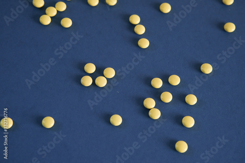 Yellow round tablets on a blue background. Free space for text