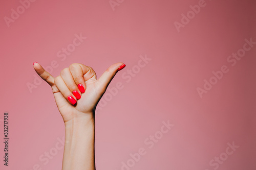 Konstfotografi Woman's hands with bright manicure isolated on pink background call me sign