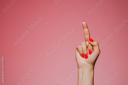 Photography Woman's hands with bright manicure isolated on pink background go away sign