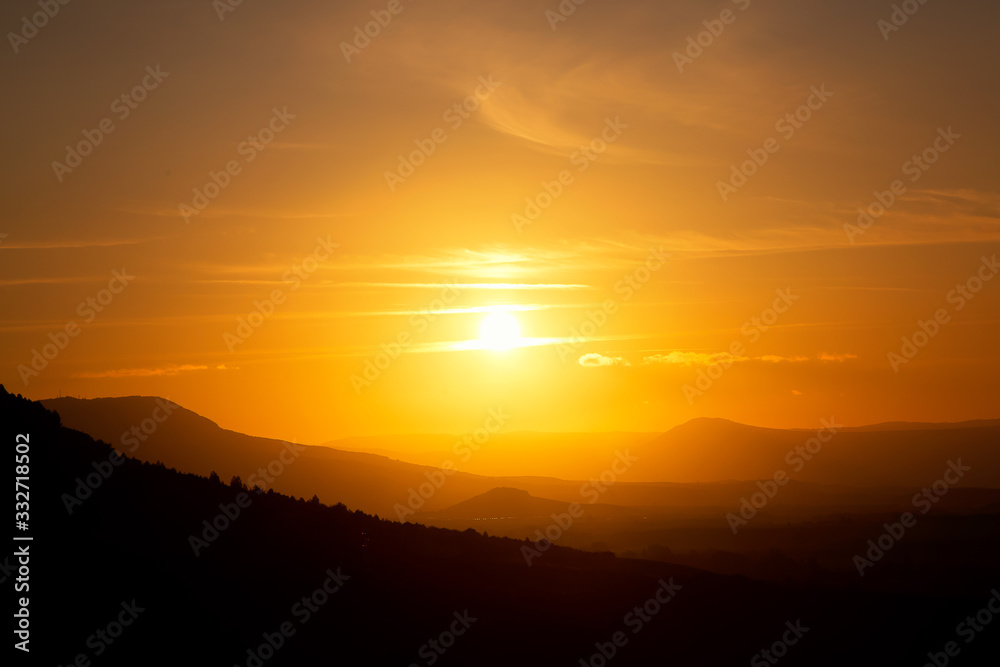 Fototapeta premium Orange and yellow sunset over the mountains