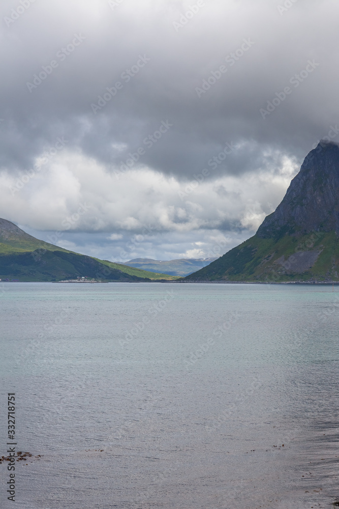 Beautiful view of the Norwegian fjords with turquoise water surrounded by cloudy sky, selective focus