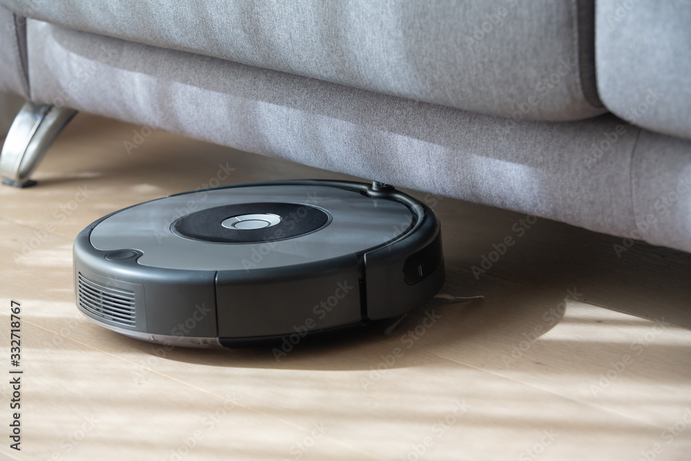 robot vacuum cleaner under a sofa. robot vacuum cleaner under a sofa.
