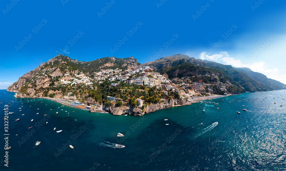 Beautiful aerial panorama view of Amalfi coast. Rocky shores and incredible beaches, Luxury yachts, boats and apartments overlooking Tyrrhenian Sea. Bright sunny day. Positano, Italy