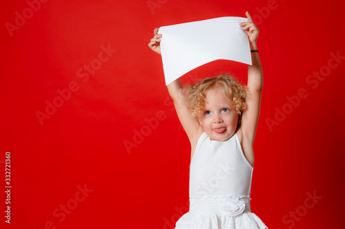 Cute little girl isolated on red holding blank paper