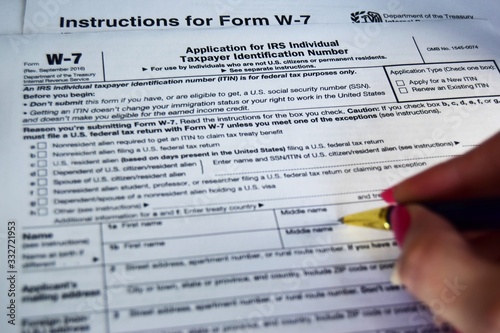 W7 tax form for US citizens, filling out a declaration and instructions. selective focus close-up.