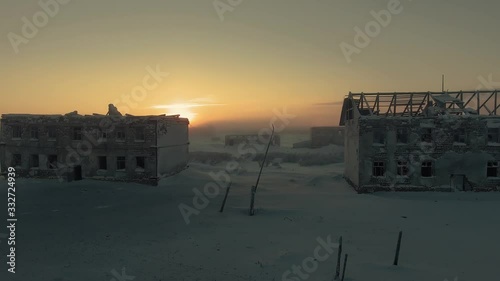The sun rises behind the ruins
