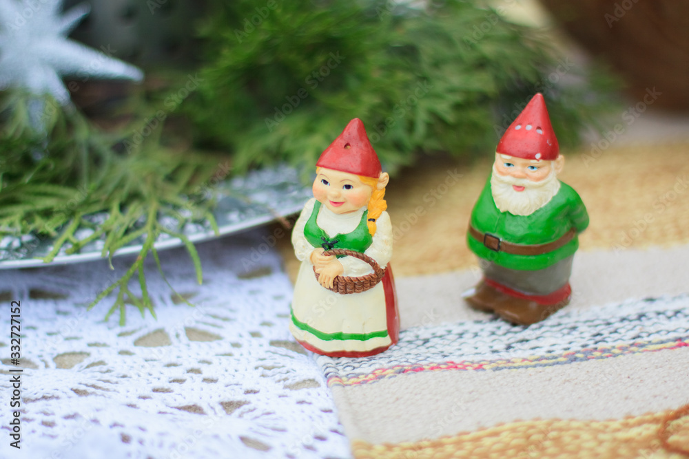 Two decorative ceramic figures of green gnomes stand on a table