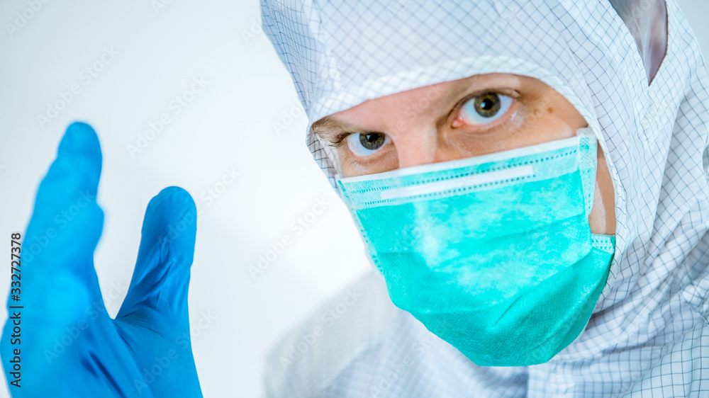 A close-up portrait of male caucasian doctor wearing a protective suit and mask A close-up portrait of male caucasian doctor wearing a protective suit and mask