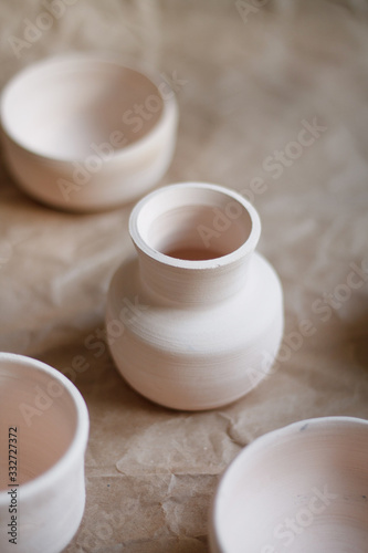 dishes made of white clay without glaze after firing on a brown background close-up. pottery