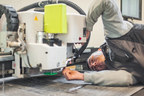 Electrical engineer repairs CNC computer numerical control knife cutting head