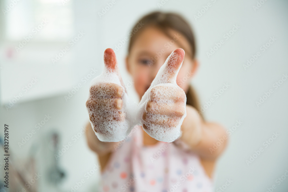 Little girl washing hands with water and soap in bathroom. Kid showing thumbs up. Hands hygiene and virus infections prevention.  - obrazy, fototapety, plakaty 