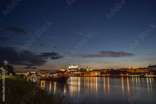 Night panoramic view on Bratislava castle with river dunaj and boat