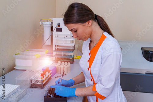 Nurse arranges test tubes with blood on a tray. Virus infection. Pneumonia testing. COVID-19 and coronavirus identification. Pandemic. photo