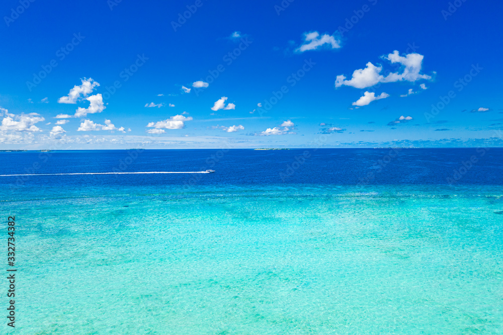 Water of ocean with clouds and blue sky and speedboat on horizon. Blue sea background, ecology environment