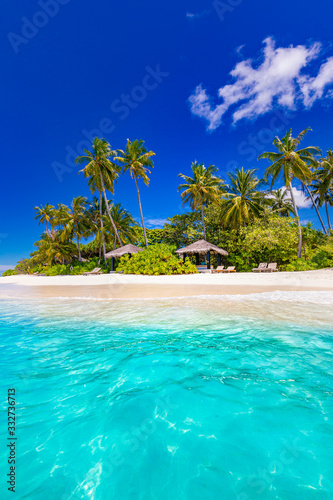 Tranquil tropical beach and sea in Maldives island with luxury water bungalows, villas under coconut palm tree and blue sky background. Perfect summer landscape, tropical island nature