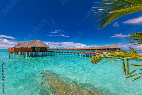 Fototapeta Naklejka Na Ścianę i Meble -  Maldives island, luxury water bungalows villas resort and wooden pier. Beautiful sky and clouds and beach background for summer vacation holiday and travel concept