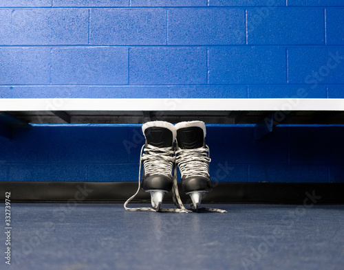 Photography Hockey skates over floor in locker room with blue background and copy space