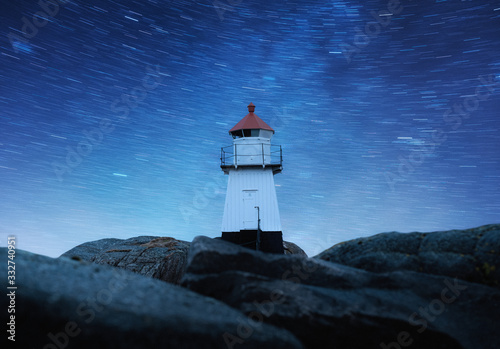 Lighthouse on the night sky background with stars. Landscape with lighthouse on the shore. Architecture at night. Travel - image