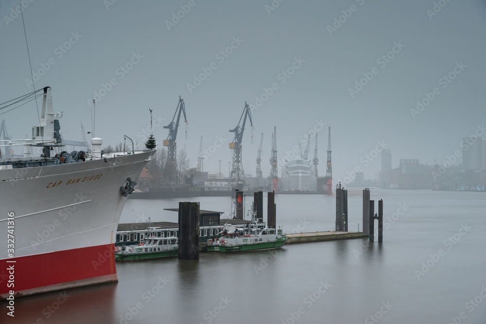 Fototapeta premium Hamburger Hafen im Nebel mit Schiff