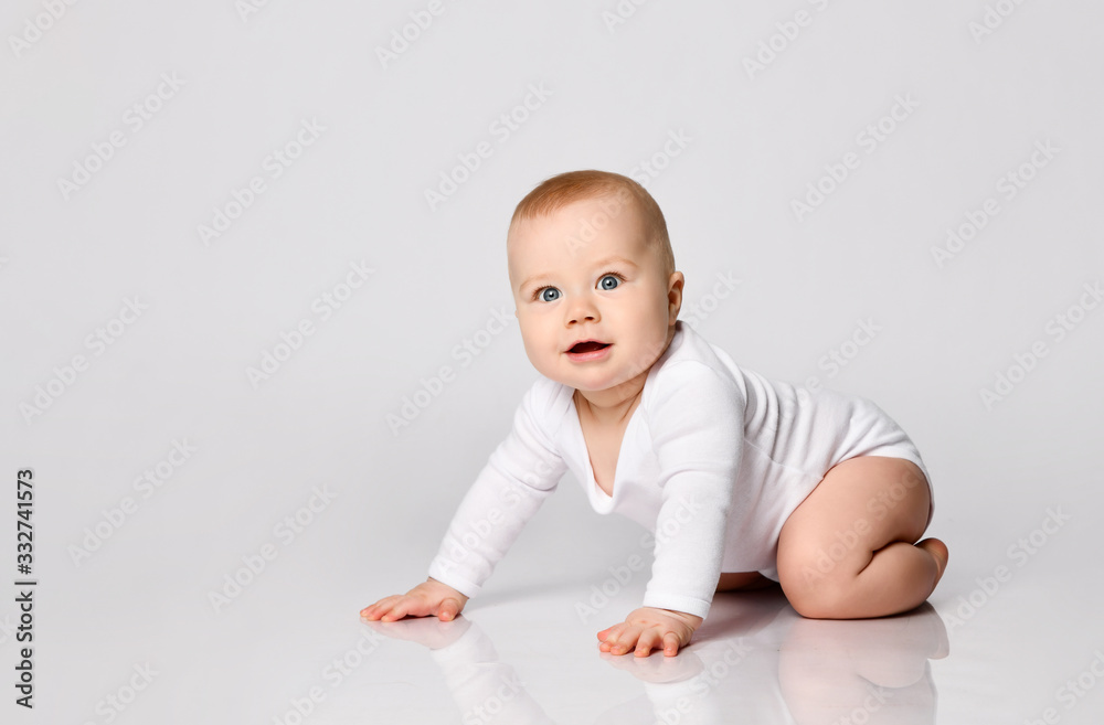 Chubby ginger baby boy in bodysuit, barefoot. He smiling, creeping on floor isolated on white background. Close up, copy space Chubby ginger baby boy in bodysuit, barefoot. He smiling, creeping on floor isolated on white background. Close up, copy space