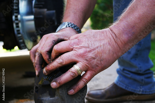 Billede på lærred Wrinkled, greasy hands of a man working with automotive parts