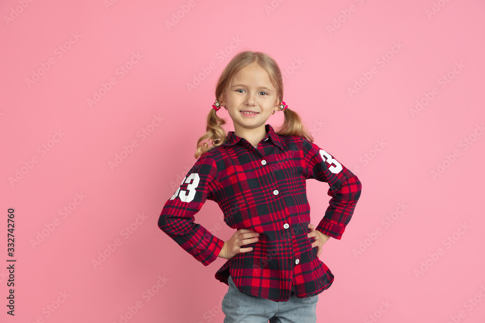 Confident smiling. Caucasian little girl's portrait on pink studio background. Beautiful female model with blonde hair. Concept of human emotions, facial expression, sales, ad, youth, childhood. Confident smiling. Caucasian little girl's portrait on pink studio background. Beautiful female model with blonde hair. Concept of human emotions, facial expression, sales, ad, youth, childhood.