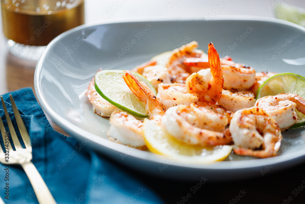 Fried tiger shrimp with lime, lemon and spices on a ceramic dish. Healthy dinner or lunch concept. Fried tiger shrimp with lime, lemon and spices on a ceramic dish. Healthy dinner or lunch concept.