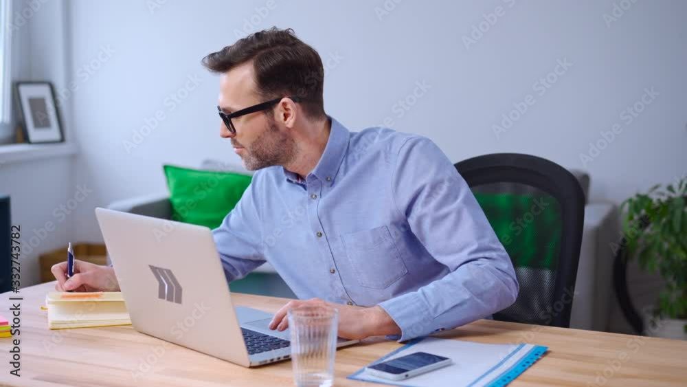 Happy businessman working from home using laptop Happy businessman working from home using laptop