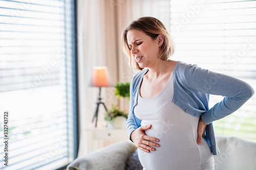 Konstfotografi Portrait of pregnant woman in pain indoors at home.