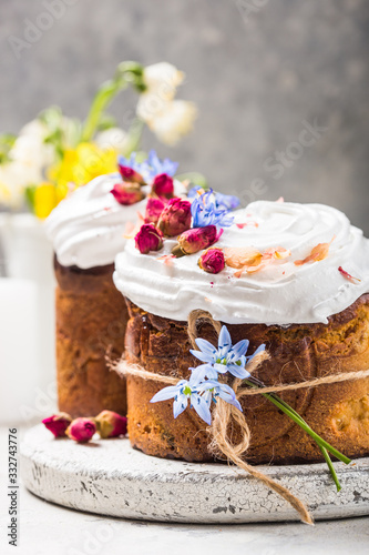 Easter Cake - Russian and Ukrainian Traditional Kulich or Brioche on a light stone background. Paska or Panettone Bread and spring flowers