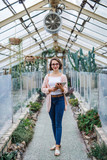 Woman researcher standing in greenhouse, using tablet.