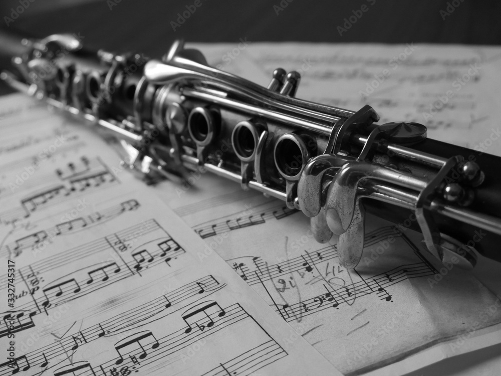 Obraz premium Close up of a clarinet music instrument and music notes . Black and white photo .
