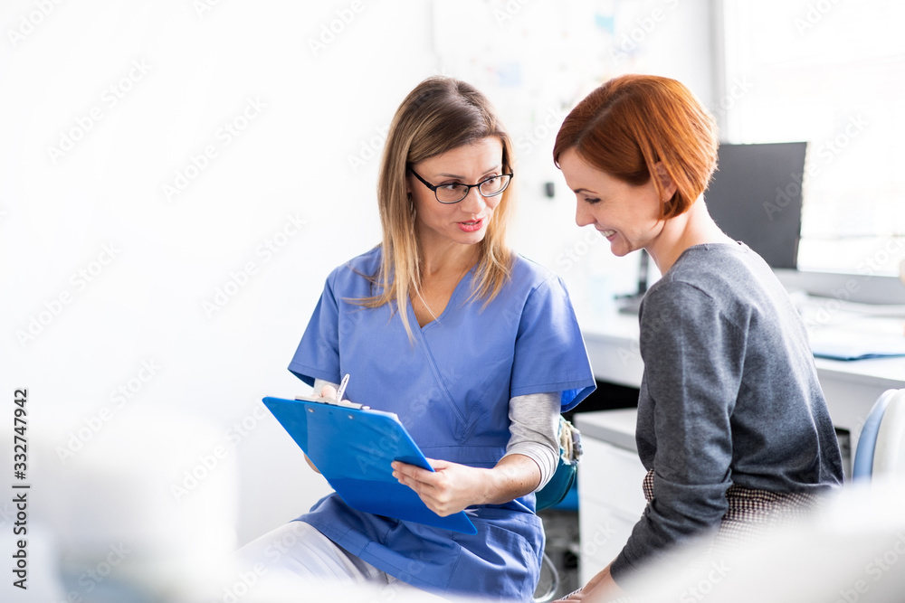 A dentist talking to woman in dentist surgery, a dental check-up. A dentist talking to woman in dentist surgery, a dental check-up.