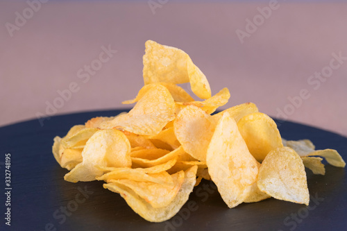 Heap of tasty potato chips on a table