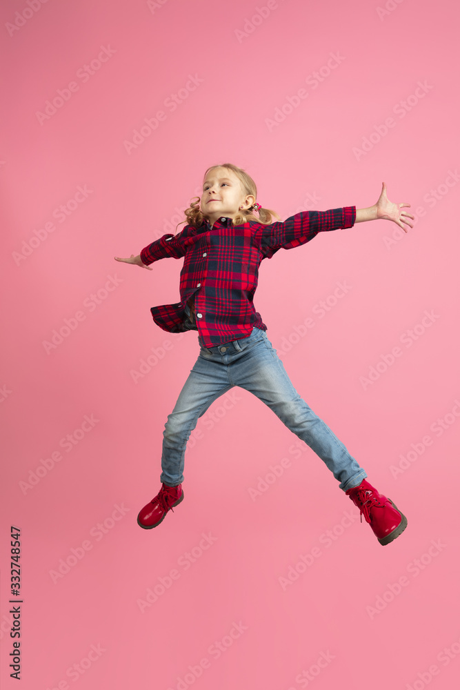 Free and happy, flying, jumping high. Caucasian girl's portrait on pink studio background. Beautiful model with blonde hair. Concept of human emotions, facial expression, sales, ad, youth, childhood. Free and happy, flying, jumping high. Caucasian girl's portrait on pink studio background. Beautiful model with blonde hair. Concept of human emotions, facial expression, sales, ad, youth, childhood.
